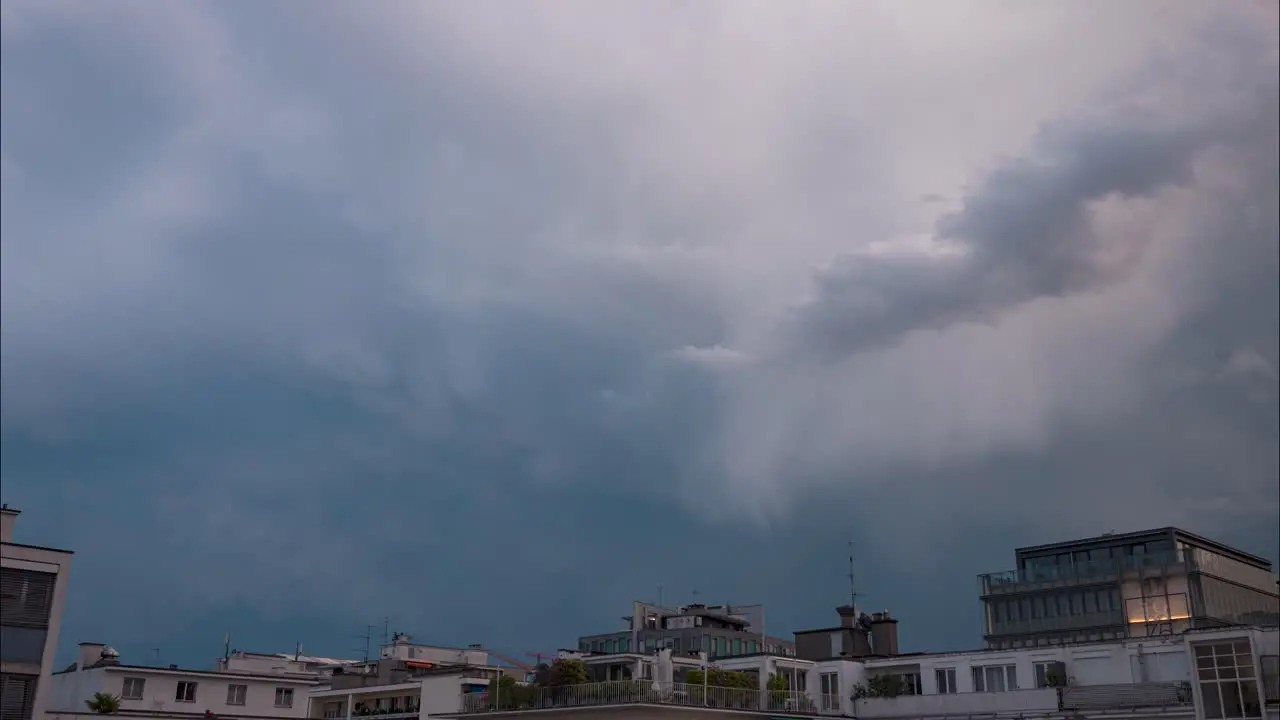 Time lapse of fast moving storm clouds over apartment buildings and residential buildings