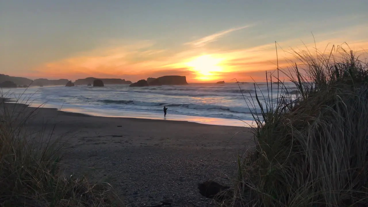 Sunset at Bandon Beach one person is fishing from the beach