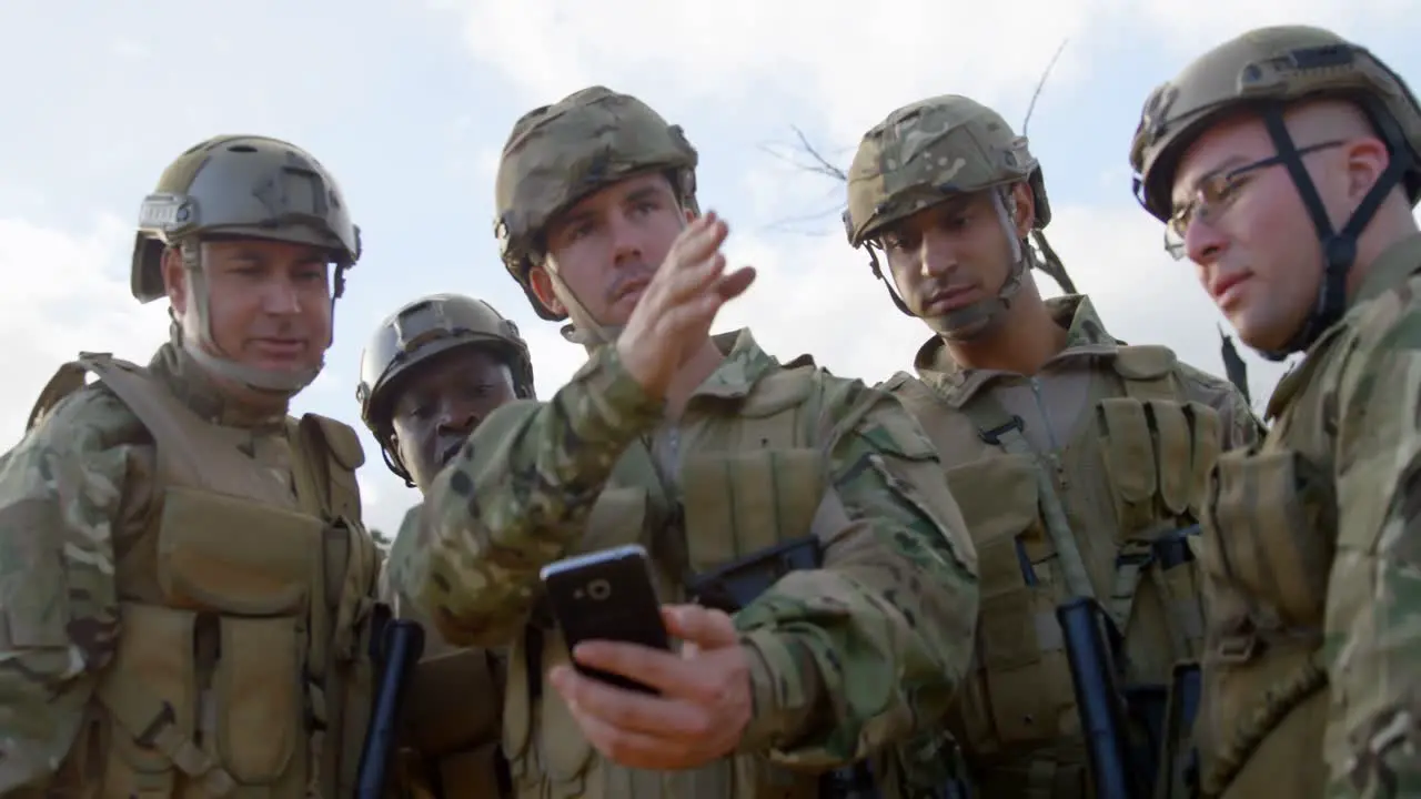 Front view of military soldiers using mobile phone during training 4k