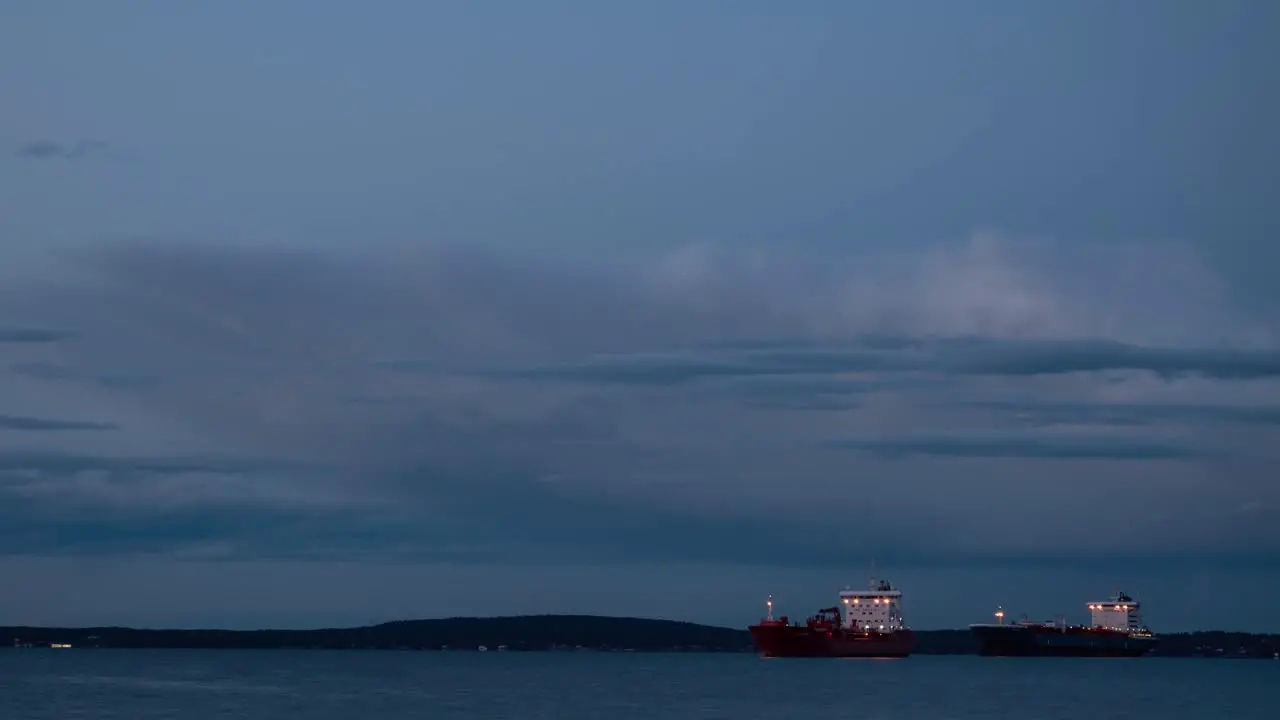 Time lapse video of two cargo ships slowly moving at sunset time in fjord