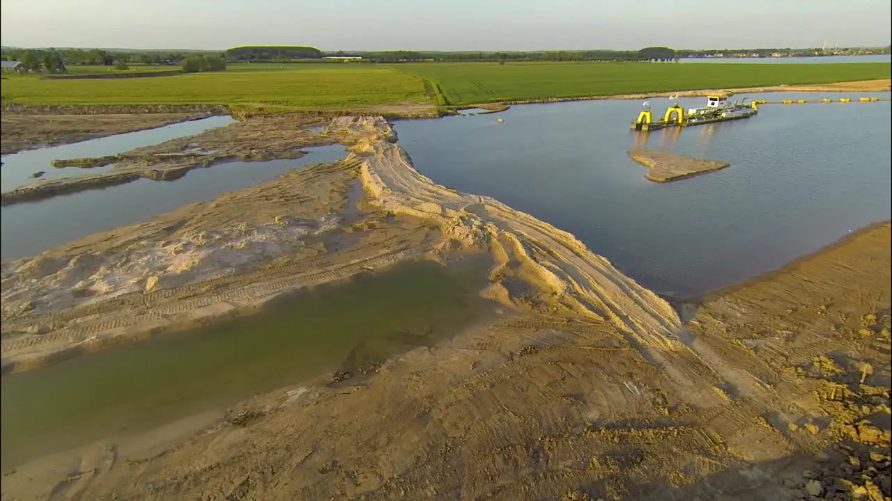 Aerial in approaching a dredger in a typical Dutch agricultural water land