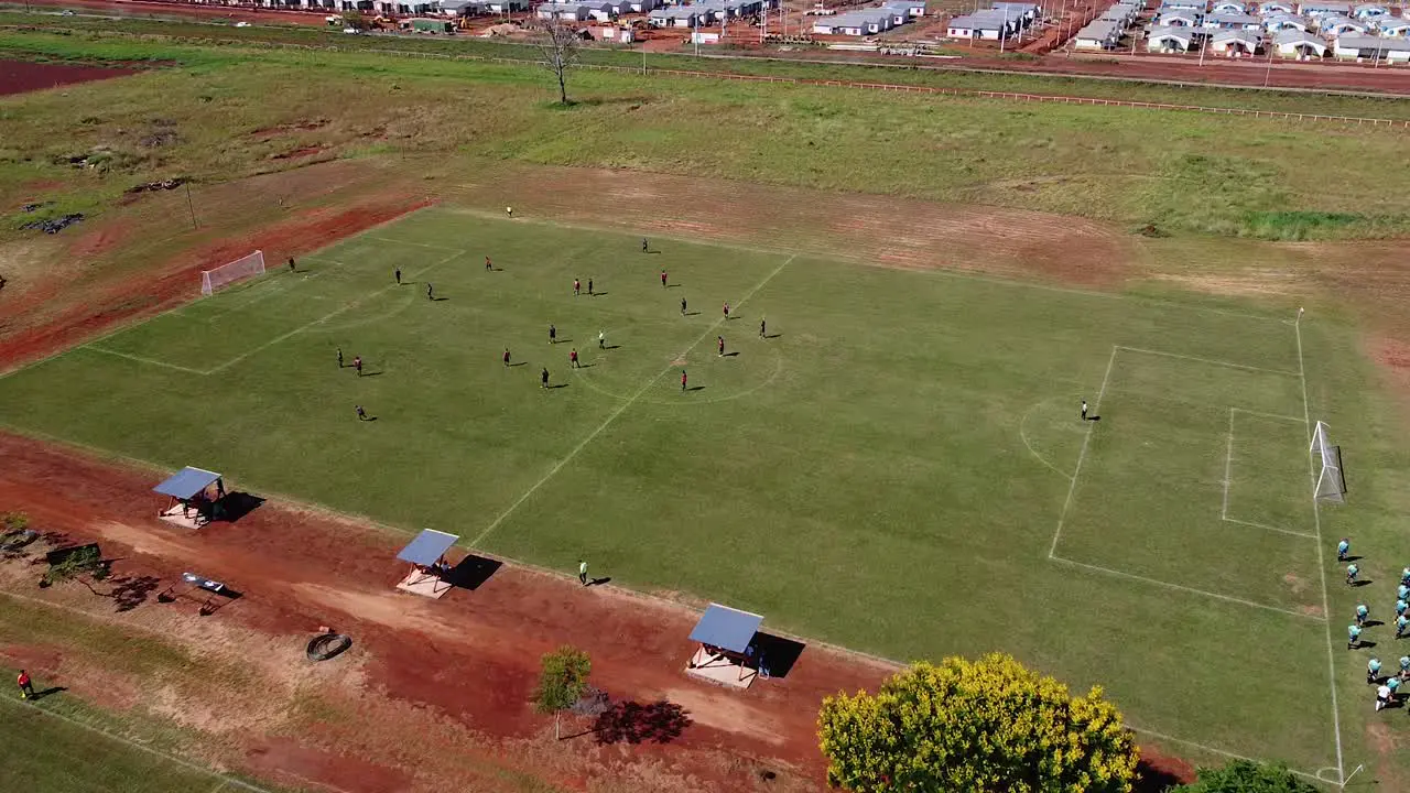 Drone zipline onto football match players running across the field