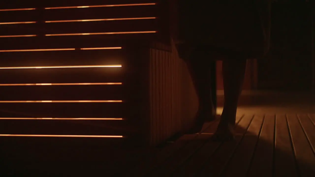 Closeup of Woman's feet entering cozy sauna during winter in wellness hotel