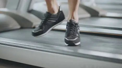 Closeup feet moving on treadmill in fitness gym