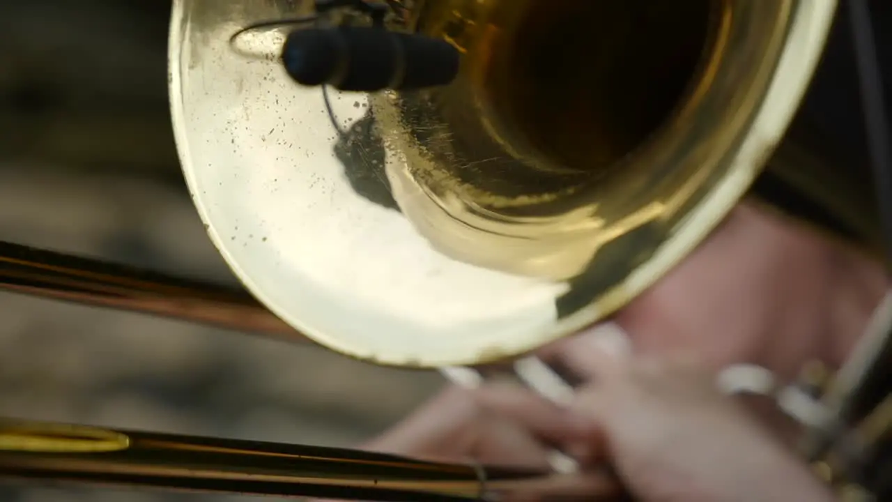 A Classic golden trumpet with microphone being played extremely close up