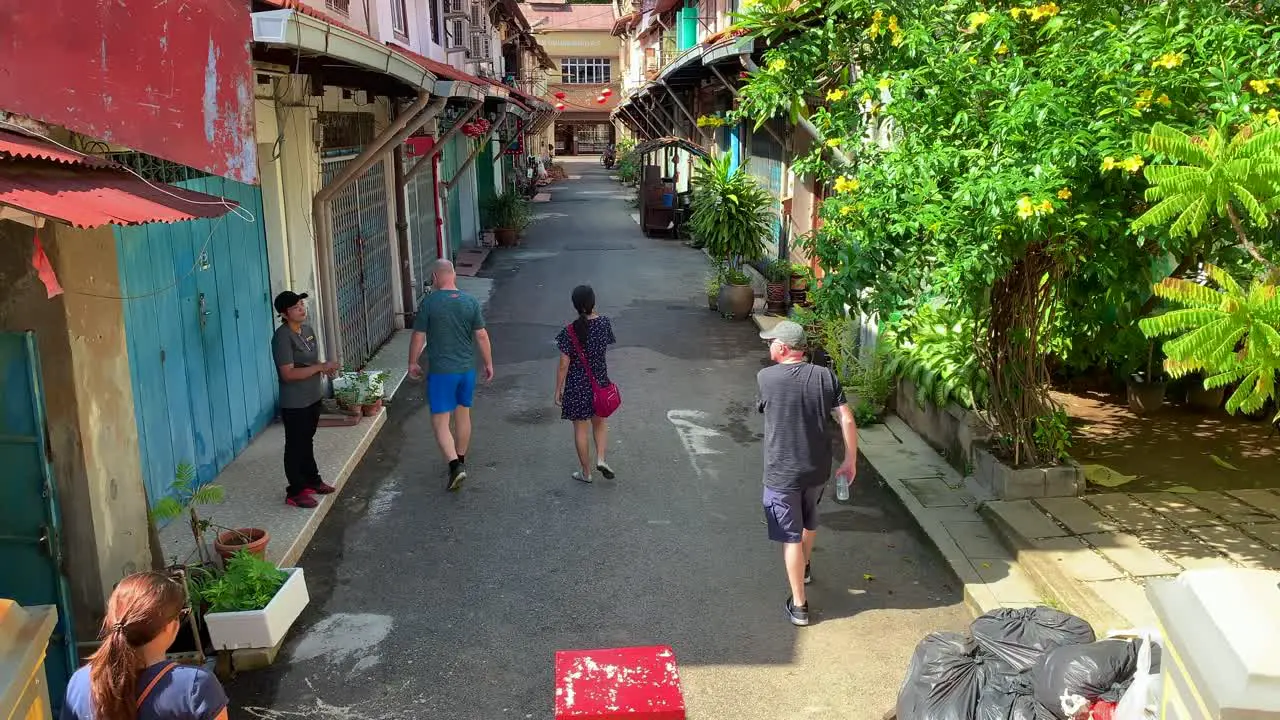 Group of tourist walking into the suburb area of Malacca with tour guide