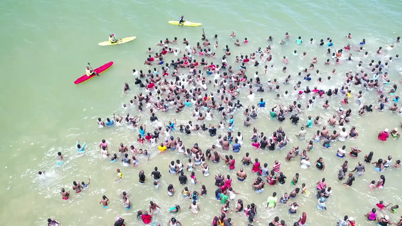 Drone shot of Large crowds in the ocean in Durban South Africa with lifeguards keeping people safe