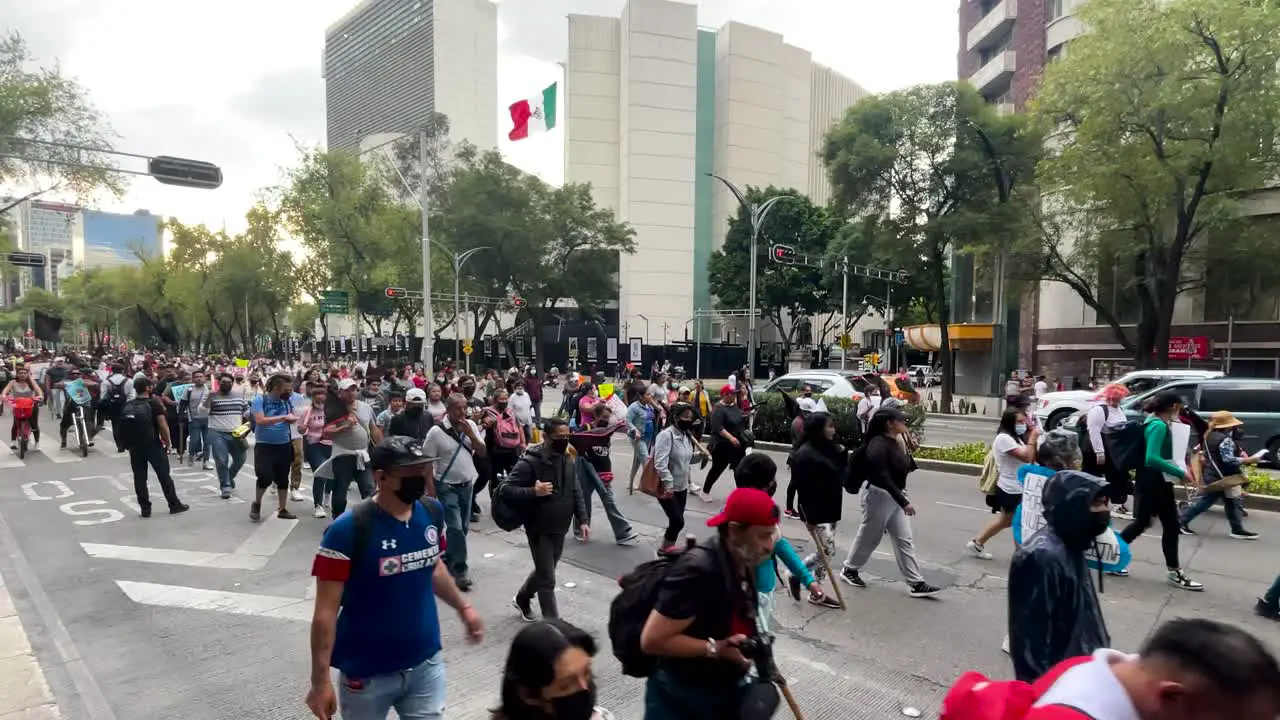 frontal slow motion view of a peaceful demonstration in front of the senate of the republic in mexico city