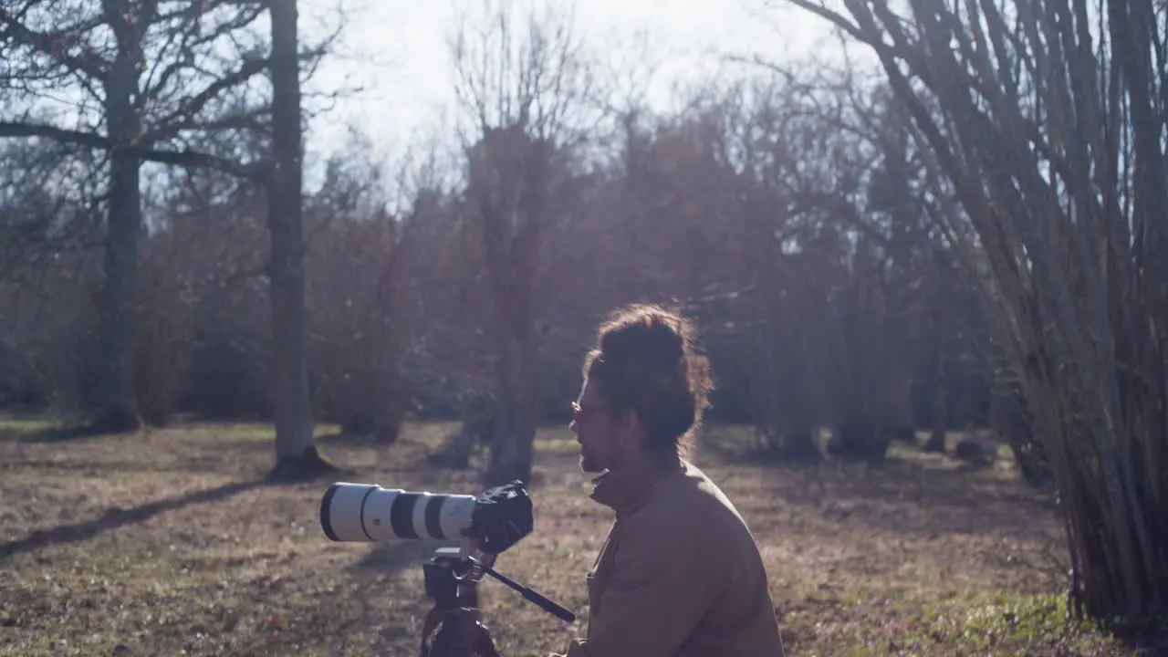 photographer walking around in a field taking photos of nature