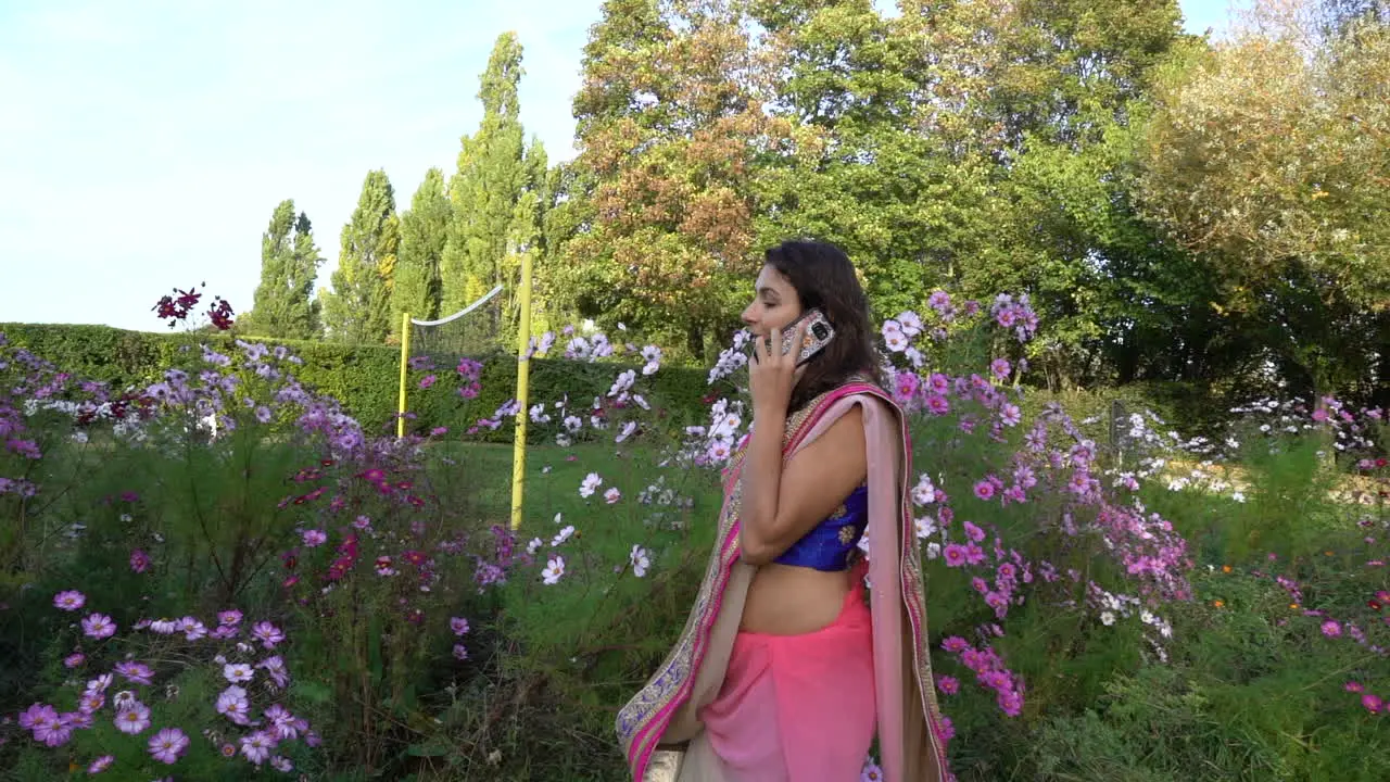 Young woman is talking on the phone in a park