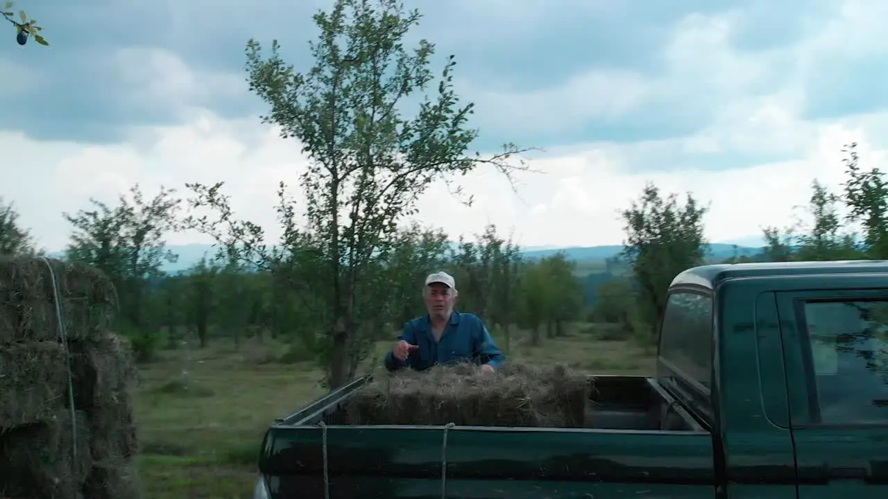 Hard workers load bales of hay in pickup truck medium shot