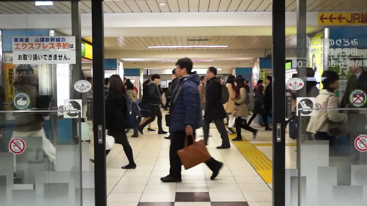 Crowd of people in Tokyo subway heading to work while access doors are closed Japan