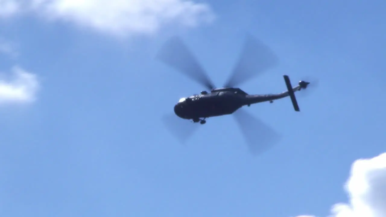 a black military helicopter flys through the air at an air show in Berlin