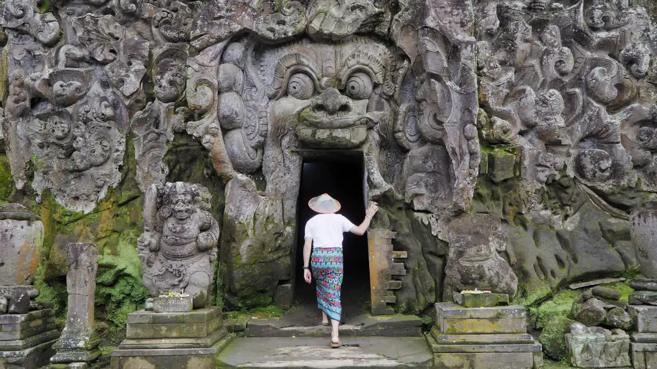 Journey into Mystery Male Tourist dressed in traditional Balinese Sarong Explores Goa Gajah Elephant Cave one of the holiest temples in Ubud Bali