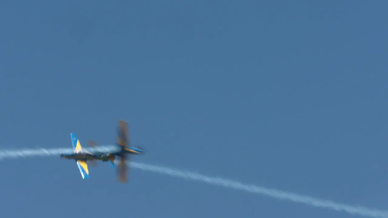 Two Brazilian stunt planes criss cross in the sky during a performance