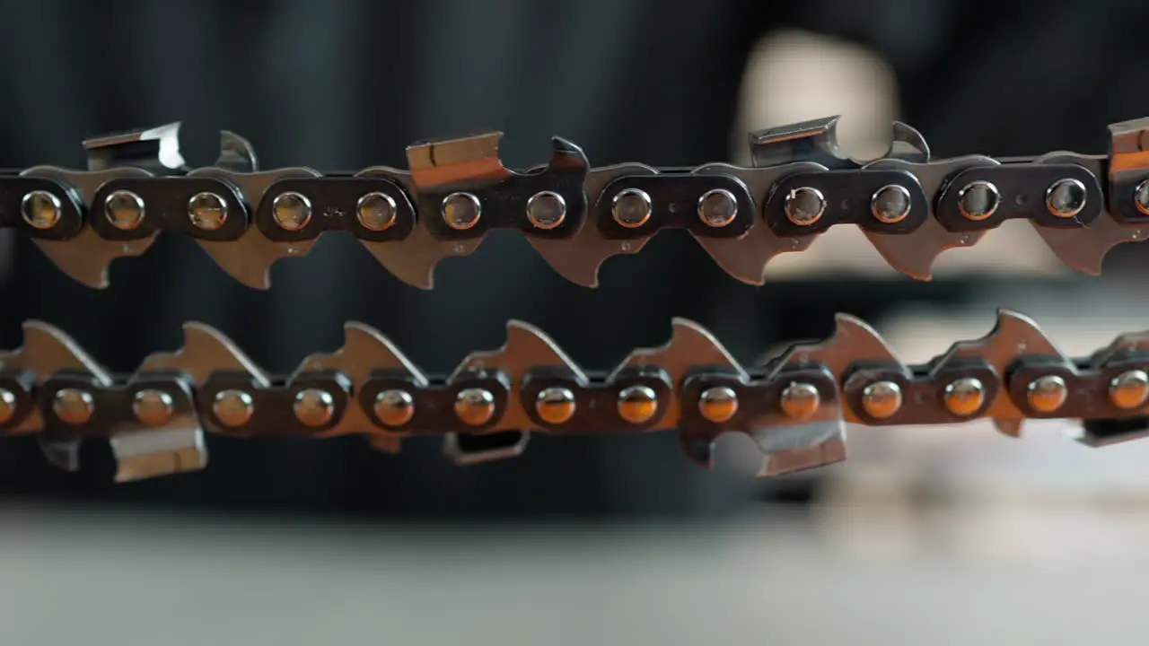 A closeup shot of a chain of a chainsaw with a blurred background