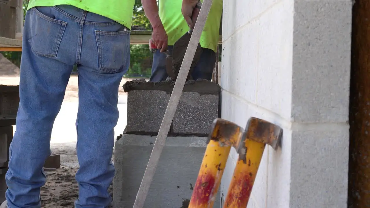 Men building the column of a stone pillar