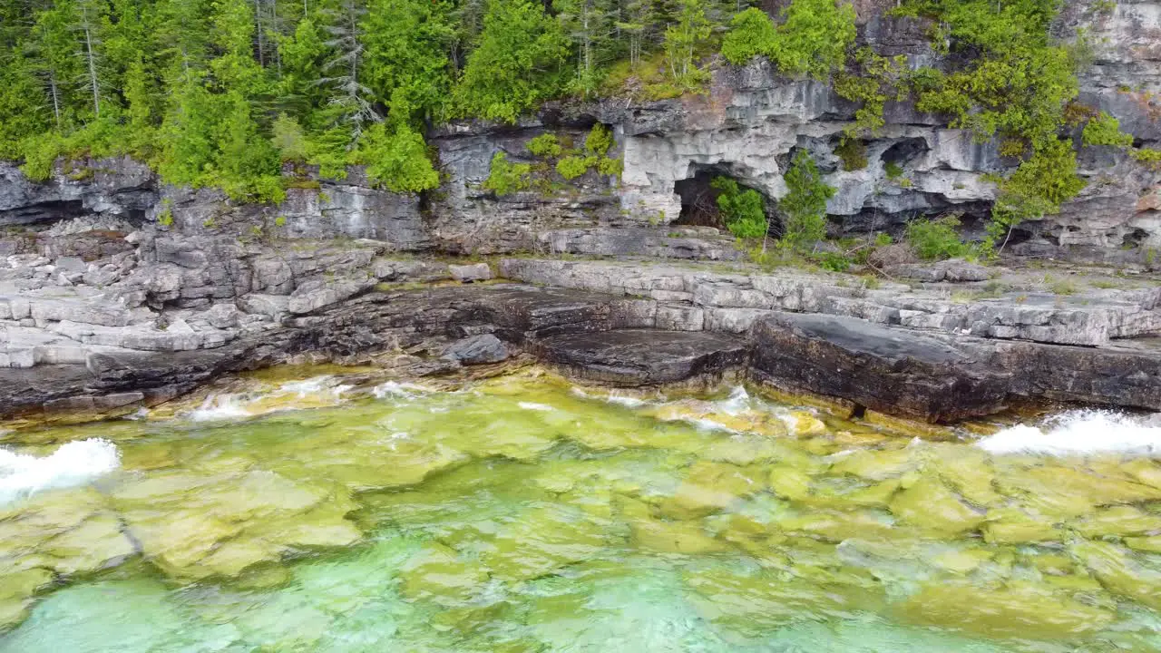 Flying to Cliff Full of Caves and Lush Green Vegetation on the Slope Bruce Peninsula Georgian Bay