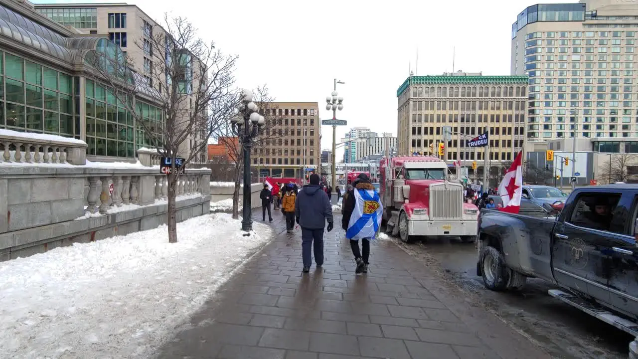 Crowds of people walk past Freedom convoy truckers protest in Ottawa Ontario Canada