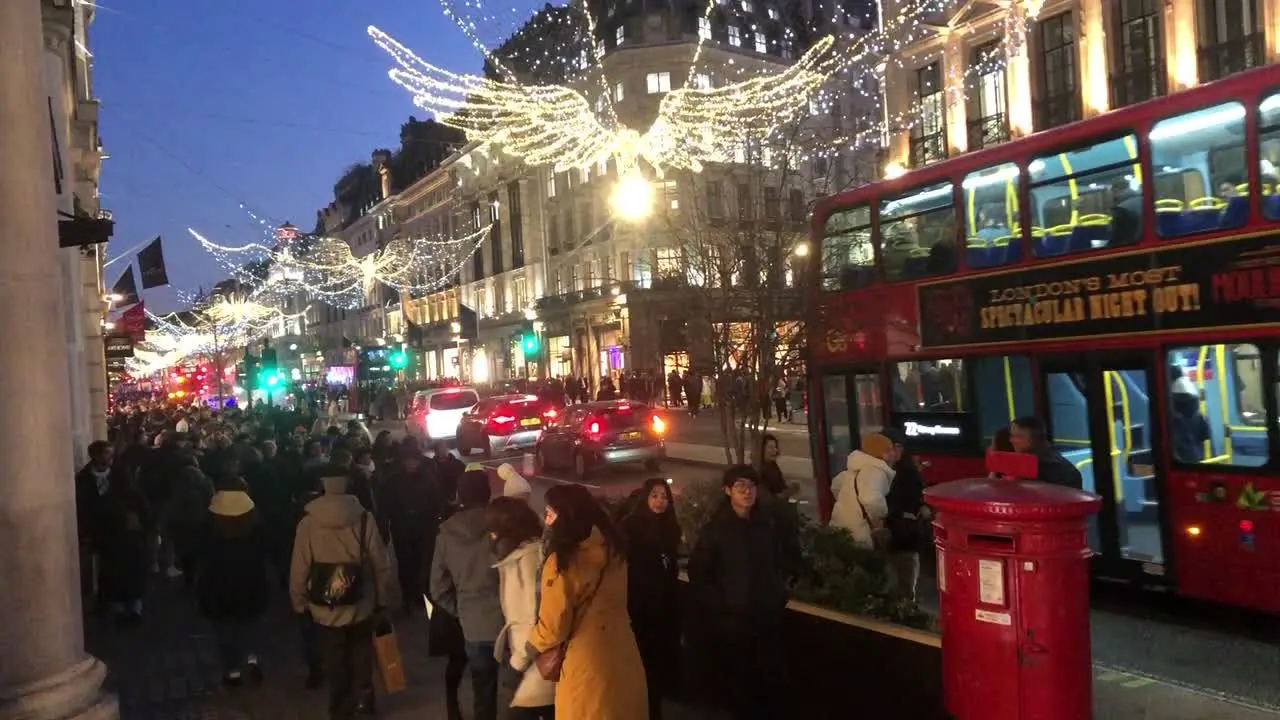 Christmas shoppers walk along Oxford Street in central London UK