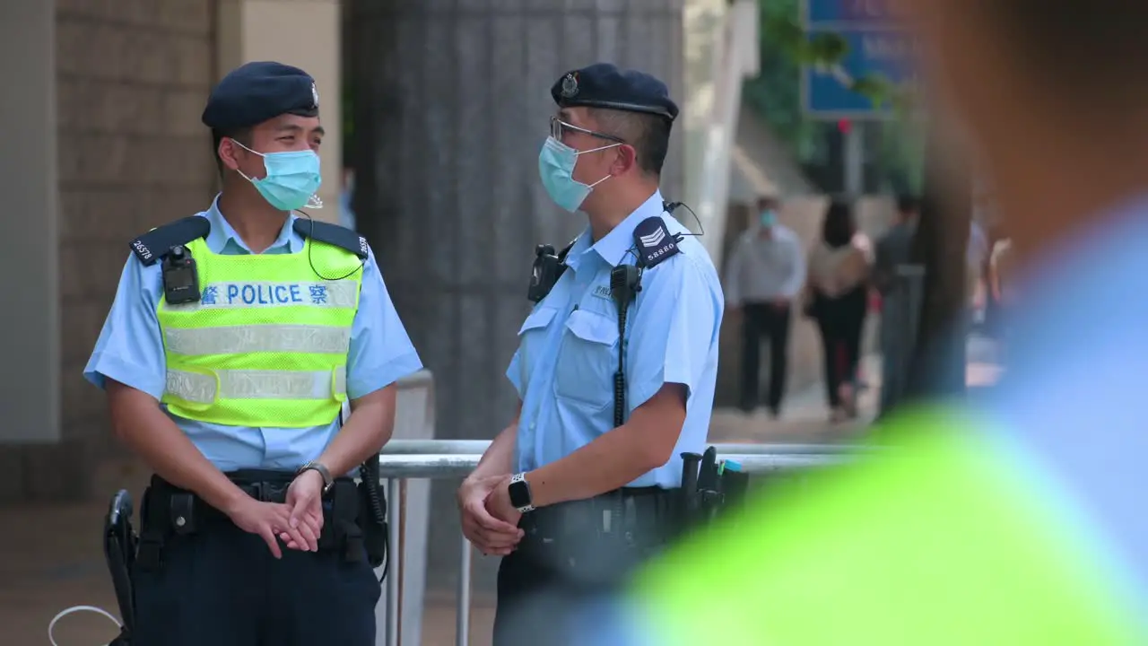 Police officers wearing face masks stand guard at the High Court premises in Hong Kong