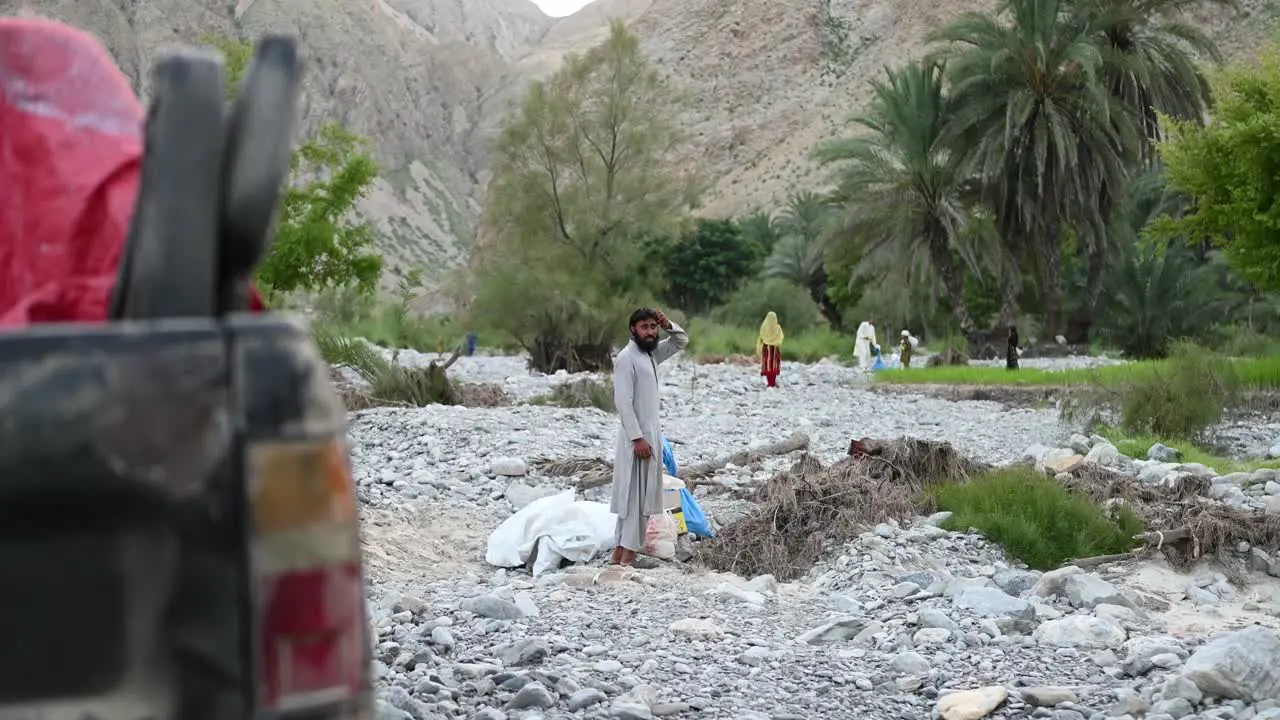 Father Waiting Beside Aid And White Tarp In Balochistan During Flood Drive