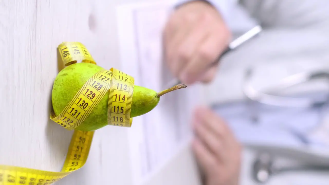 Vertical video of Nutrition appointmente pear and measure tape on Table