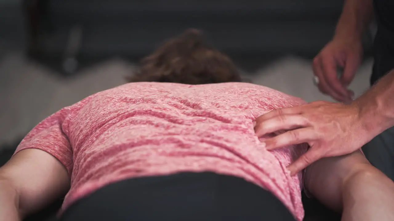 Massage therapist pressing on patient's back muscles slider push in physical therapy doctor's office