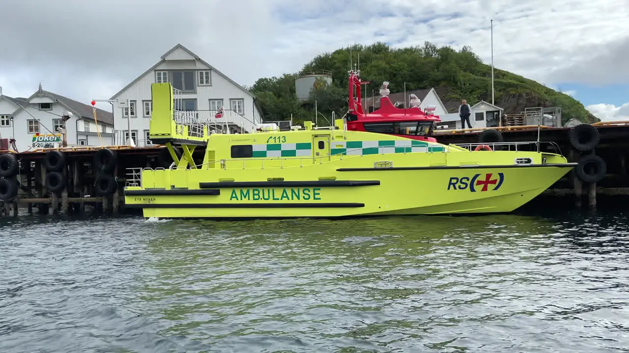 Medium shot passing an ambulance boat moored to a dock in the city of Tonnes Norway