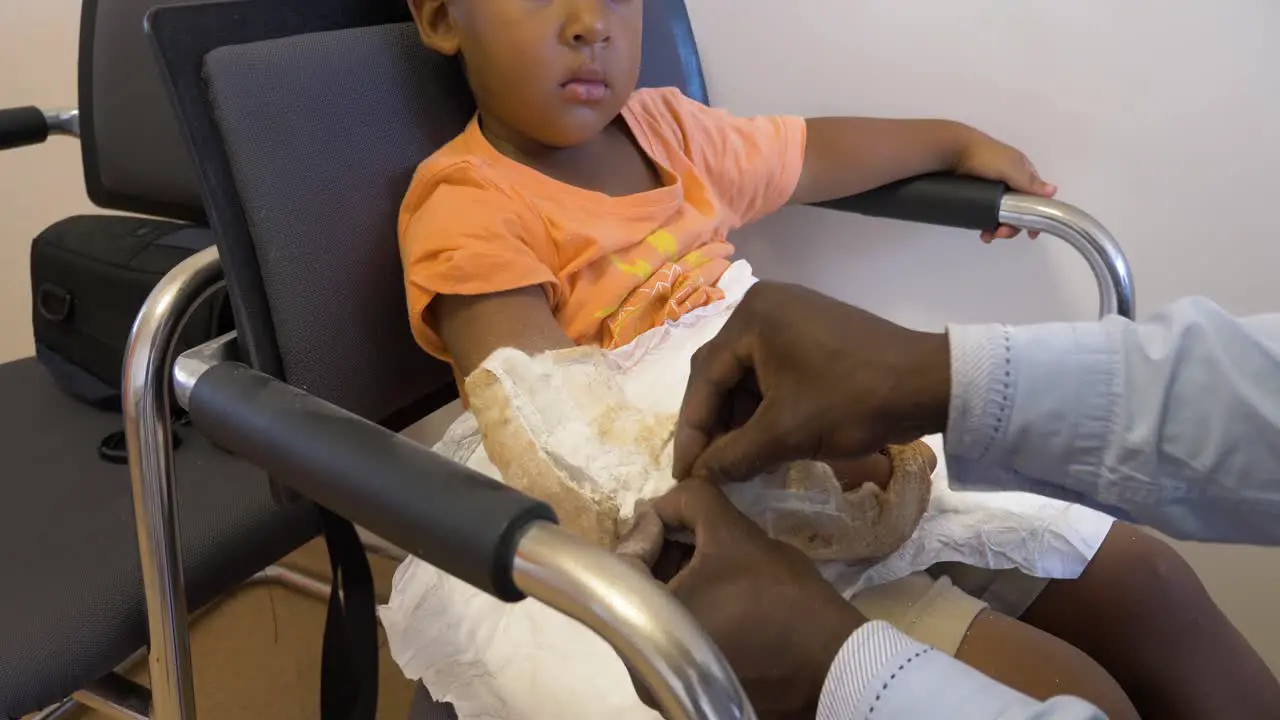 A young mixed raced child having a cast removed from his arm after a broken bone has healed