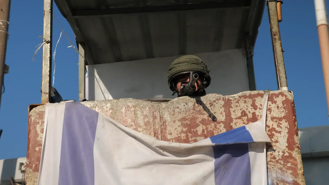 lurking IDF soldier with sniper in rusty Observation tower arch shot