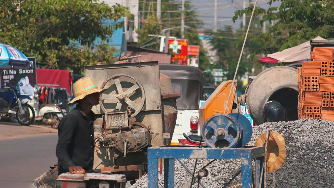 Close Shot of a Worker Supervising a Gasoline Powered Pulley Machine at the Construction Site