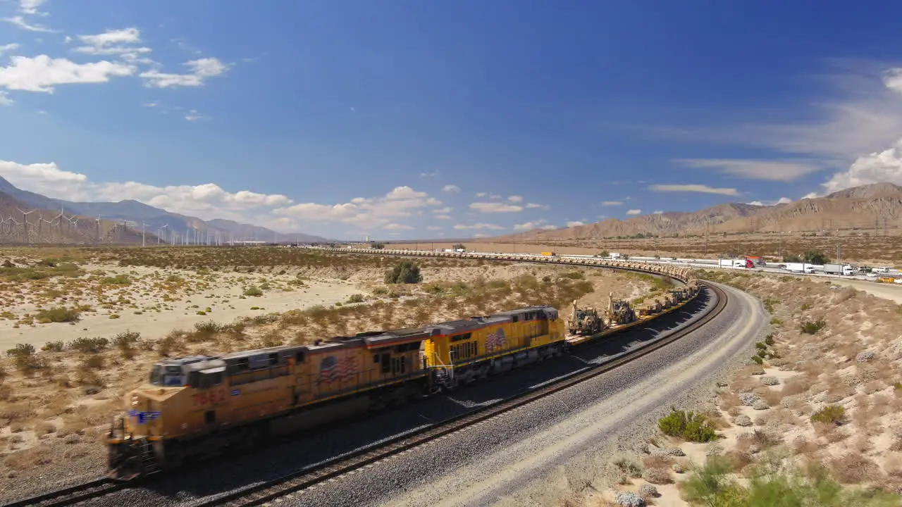 Aerial view of train carrying hundreds of US military vehicles tanks and humvees are transported by railway through the desert outside Palm Springs