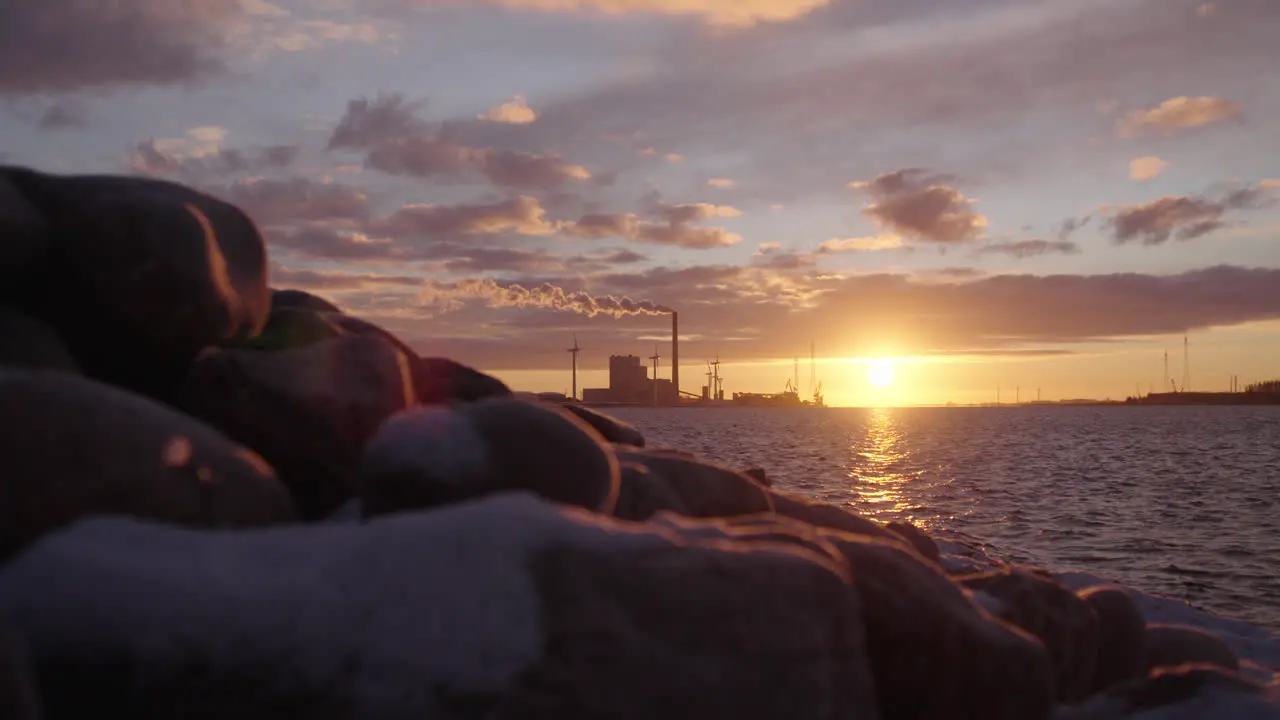 Slow Motion shot of a beautiful sunrise with a stone dike in the foreground