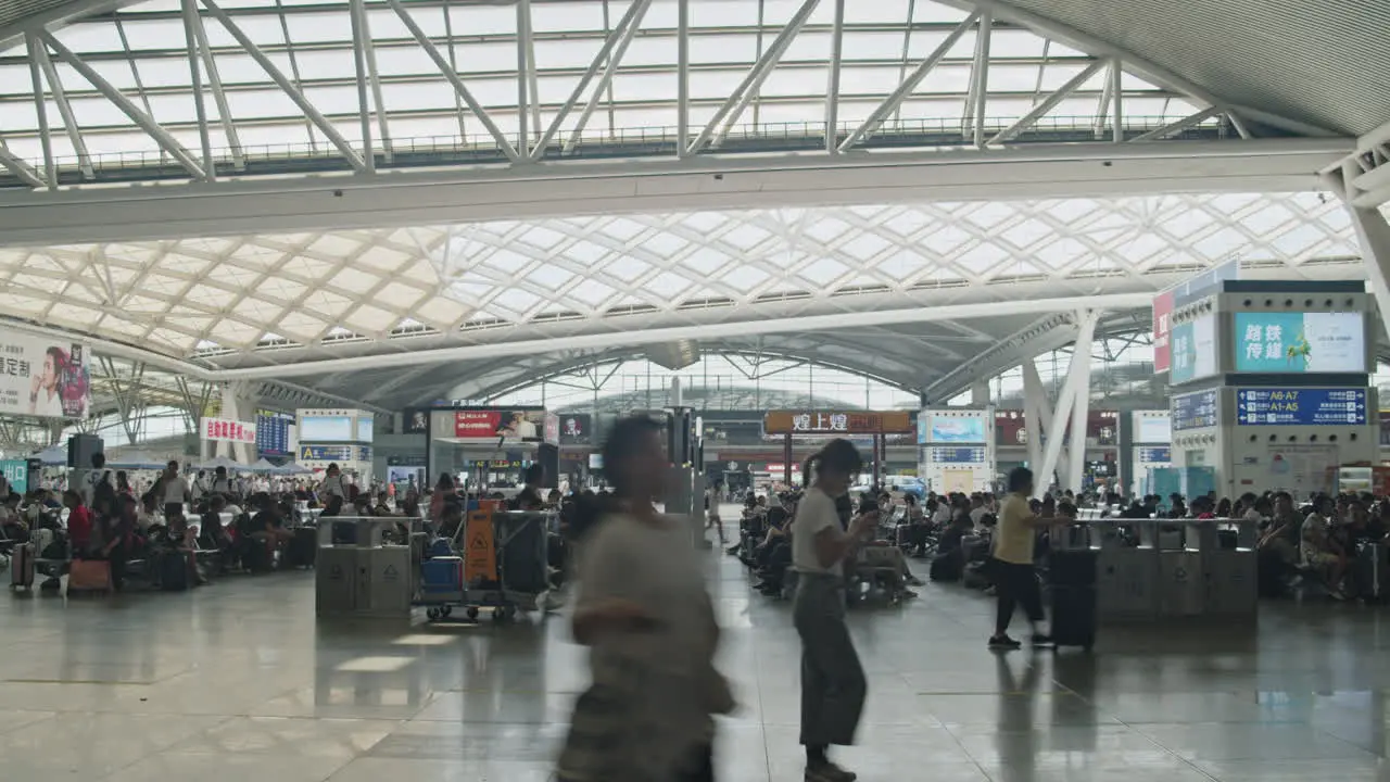 Guangzhou high speed train South railway station waiting hall with numerous passengers passing by and sitting on the seats Guangzhou China