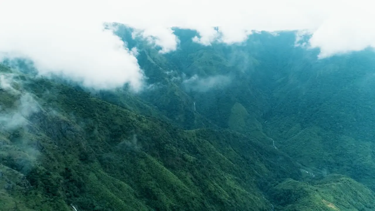 Dramatic panoramic view with green slopes of the mountains covered by big clouds aerial shot