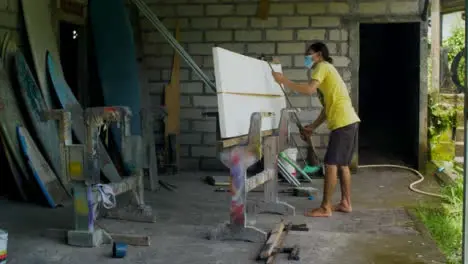 Handheld Shot of Surfboard Shaper Looking at Polystyrene Board