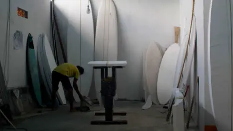 Handheld Wide Shot of Surfboard Shaper In Their Workshop