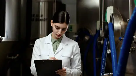 Woman with clipboard in brewery