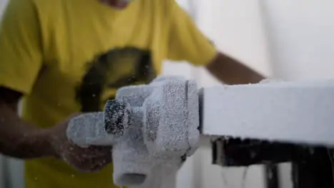 Handheld Close Up Shot of Surfboard Shaper Using Power Tool On Polystyrene Board