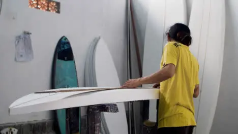 Handheld Wide Shot Revealing a Surfboard Shaper In Workshop