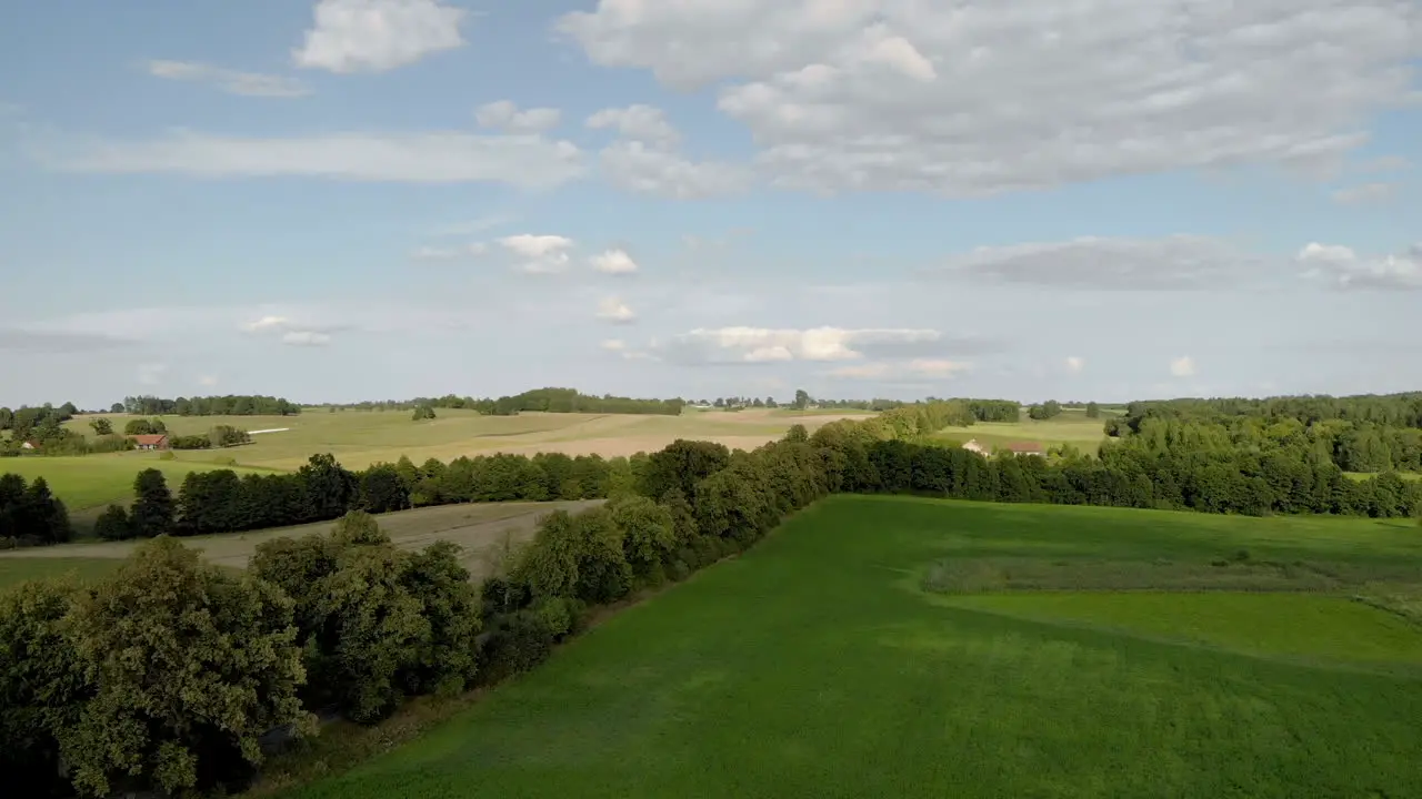 Beautiful view over the rural landscape flight over the trees on the horizon you can see trees and blue sky with clouds Eastern Poland in warmia and masuria