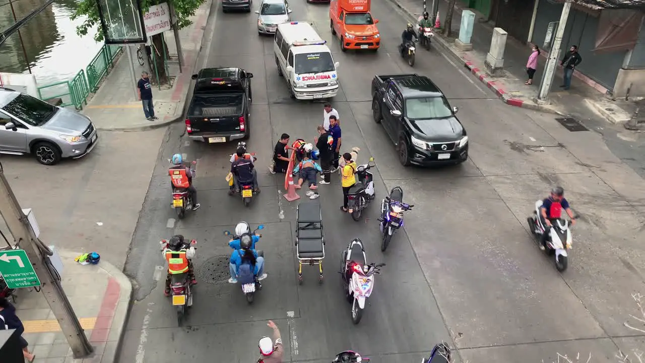 Ambulance And Medical Team In A Vehicular Accident Scene In Bangsue Bangkok Thailand Approaching The Injured Motorist Lying On The Street high angle shot