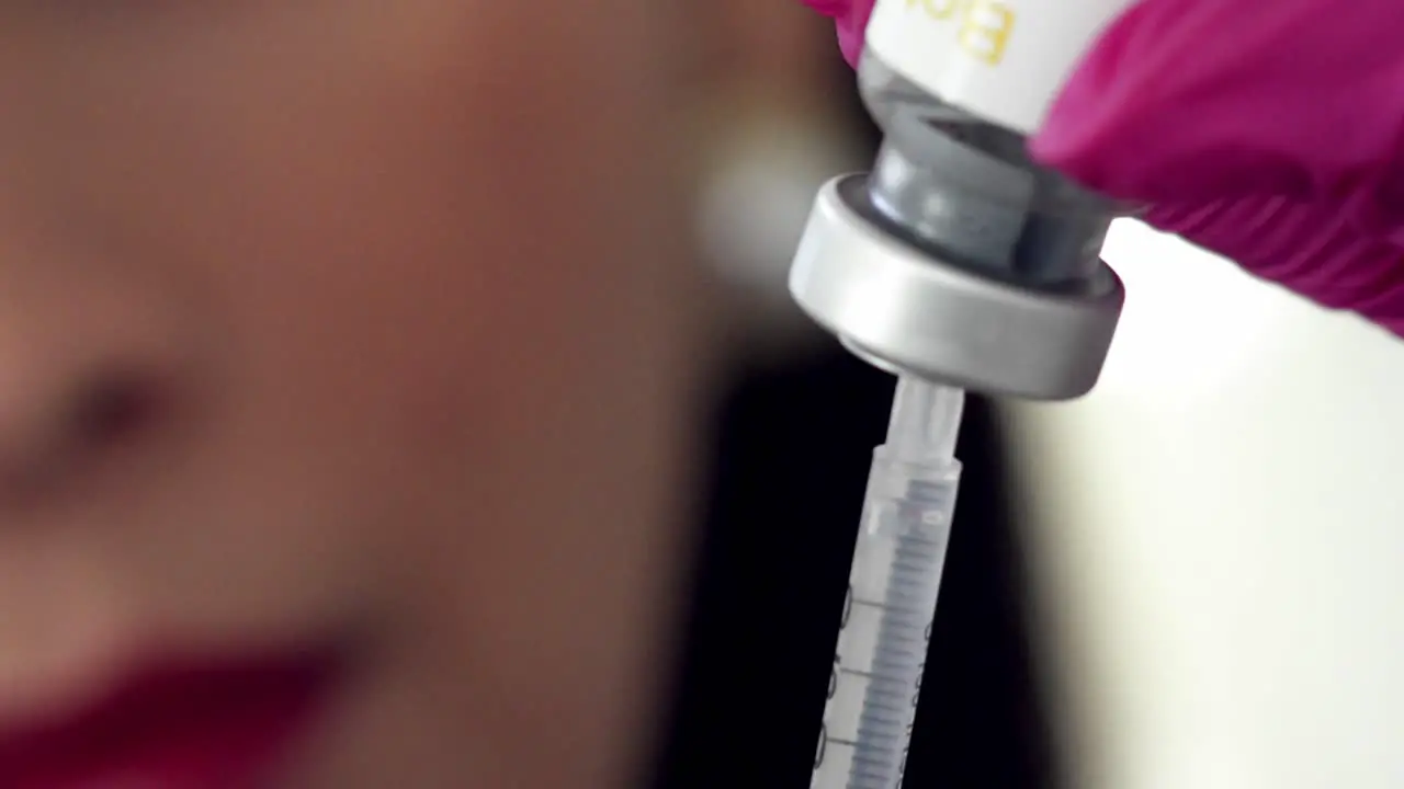 Filling a syringe from a vial of medication isolated close up