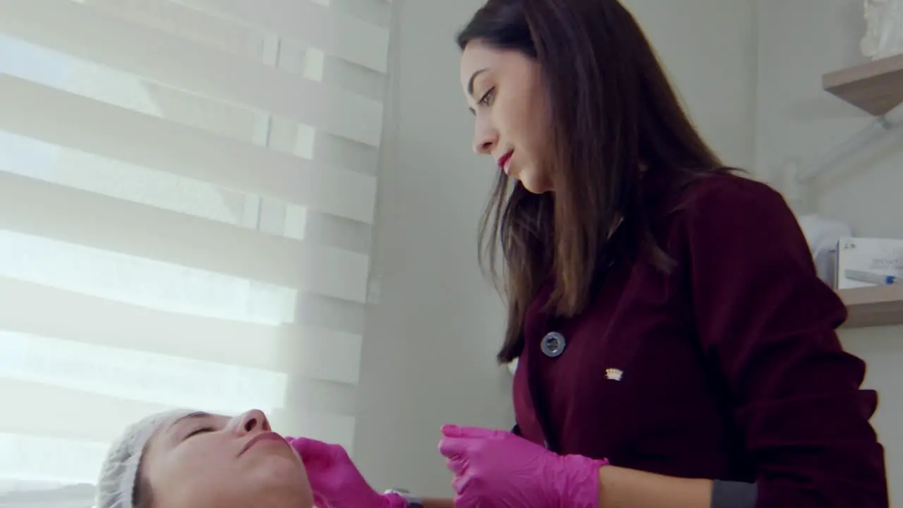 Hispanic doctor preparing a patient's face for Botox injections