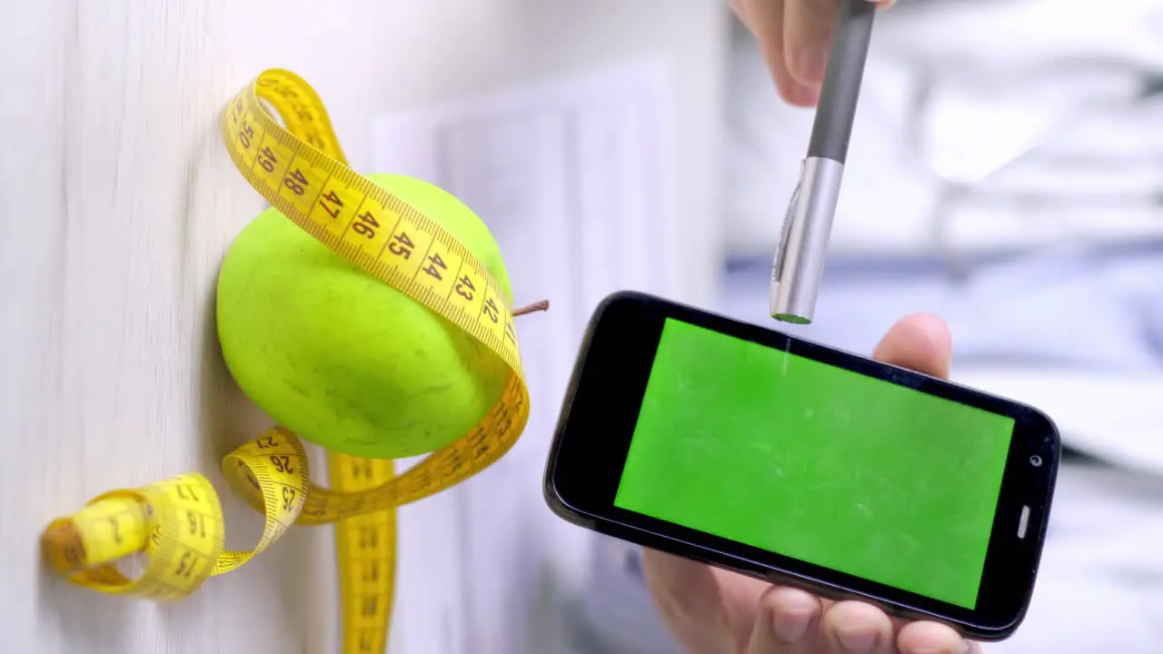 Vertical video of nutritionist points to smartphone with green screen Healthy eating