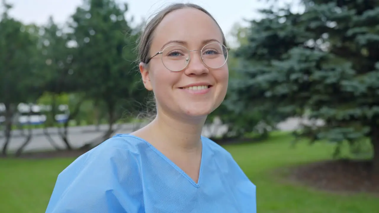 Young Nurse Takes off Covid Mask Outside in a City Park Smiling with a Close Up Slow Motion Shot