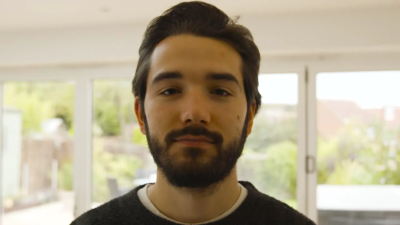 Male wearing and removing mask and smiling at camera