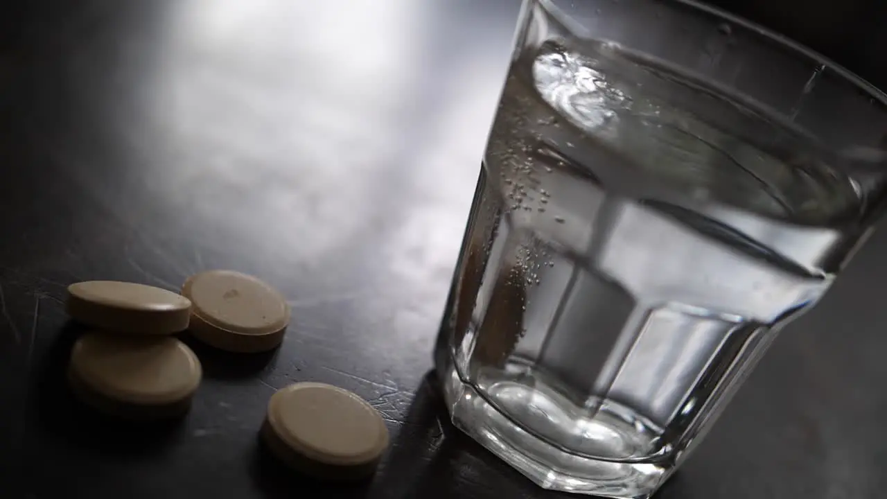 Effervescent vitamin C supplement tablet dissolving in glass of water