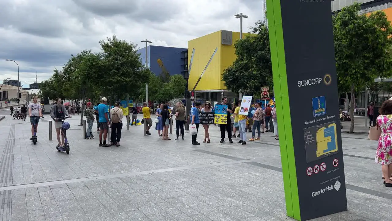 Panning down shot showing group of protestors gathered peacefully at Brisbane Square showing supports and love for people of Ukraine whose country is unlawfully invaded by Russian military